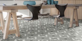 Tile patterned vinyl flooring in a kitchen under a wooden dining table